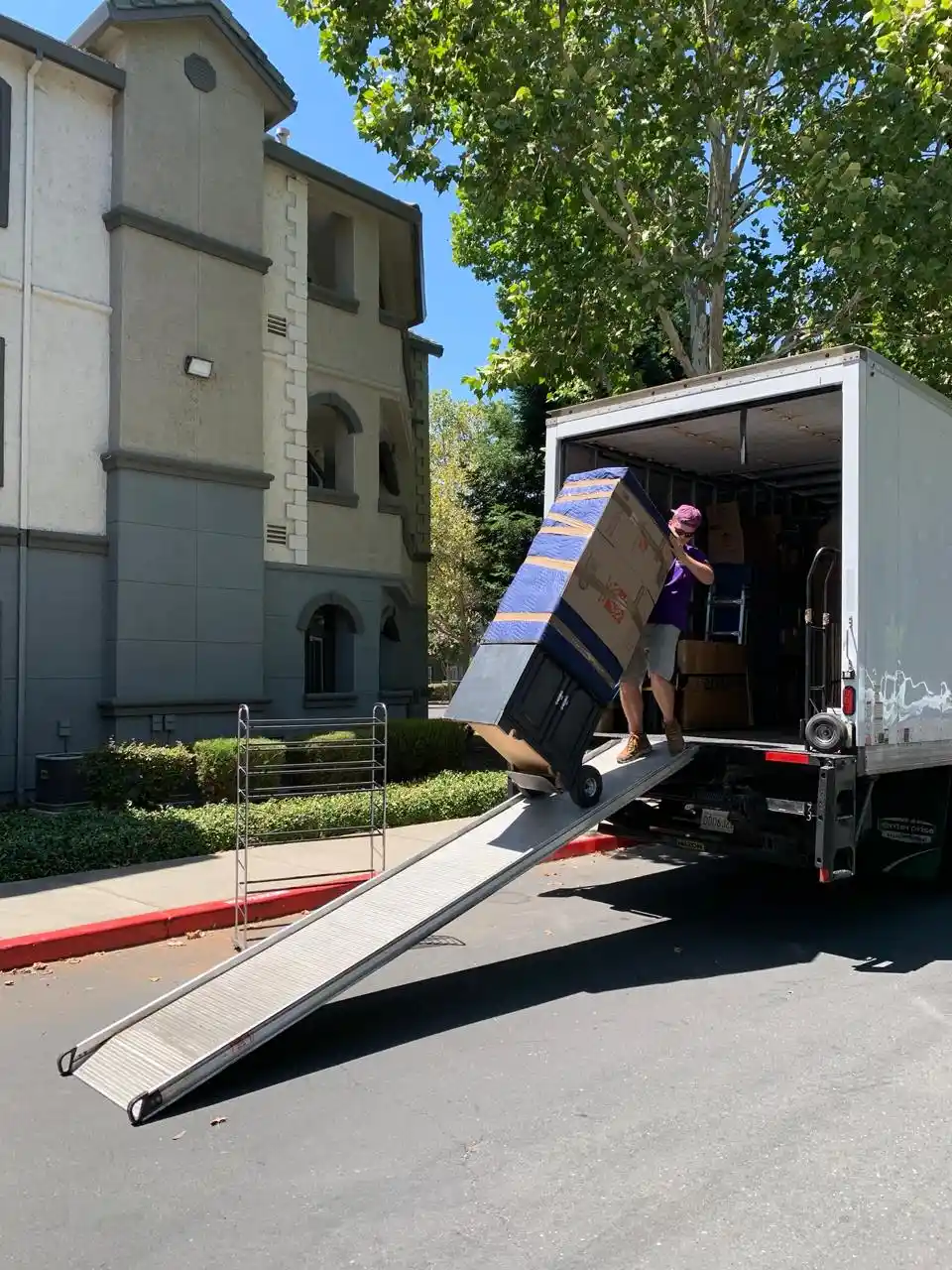 Mover guiding boxed items down the truck ramp