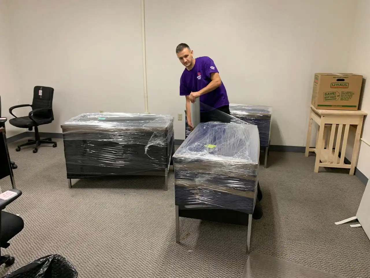 Mover shrink-wrapping office desks for a commercial move
